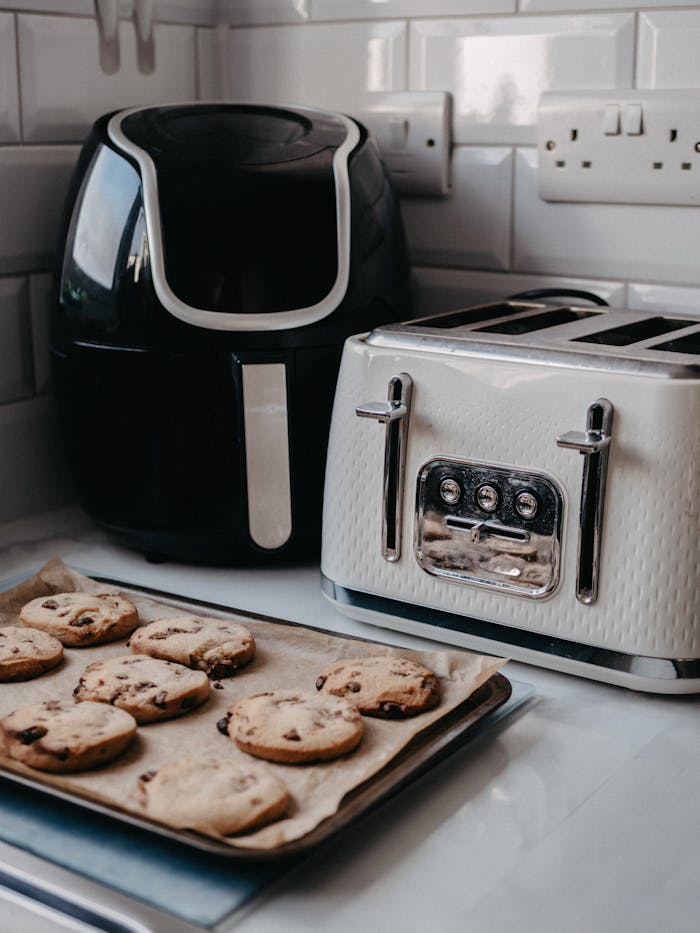 services-04 Freshly baked cookies on tray beside air fryer and toaster.
